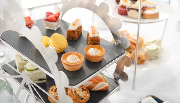 Afternoon tea pastries and sandwiches on a Ferris wheel stand for London Eye experience.