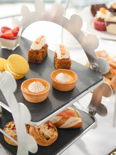 Afternoon tea pastries and sandwiches on a Ferris wheel stand for London Eye experience.
