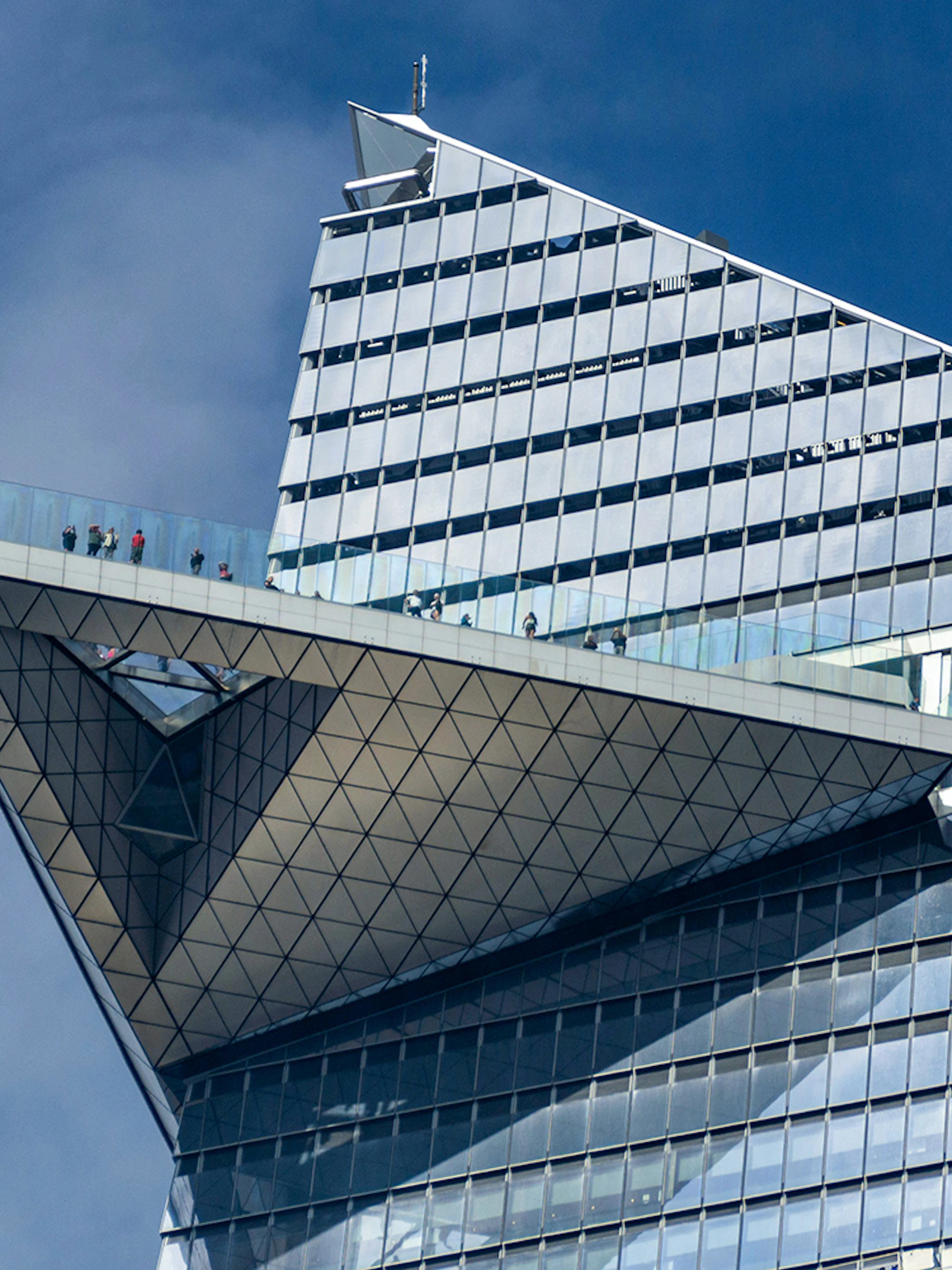 Edge observation deck with visitors on glass platform, New York City.