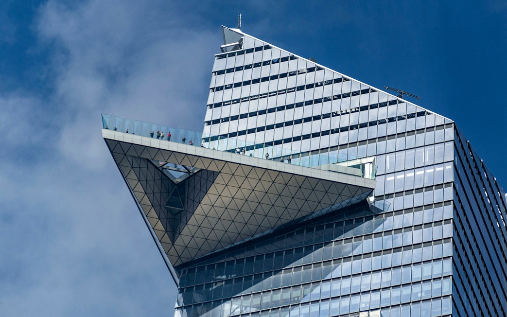 Edge observation deck with visitors on glass platform, New York City.