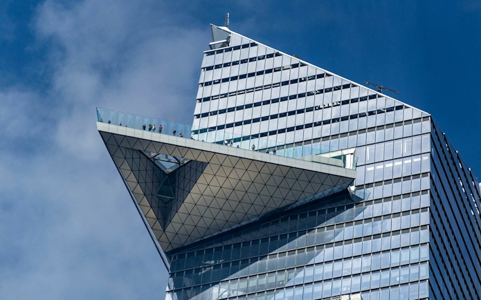 Edge observation deck with visitors on glass platform, New York City.