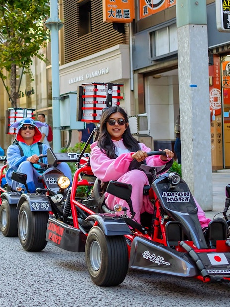 People driving go-karts in costumes on Asakusa streets during a 60-minute tour.