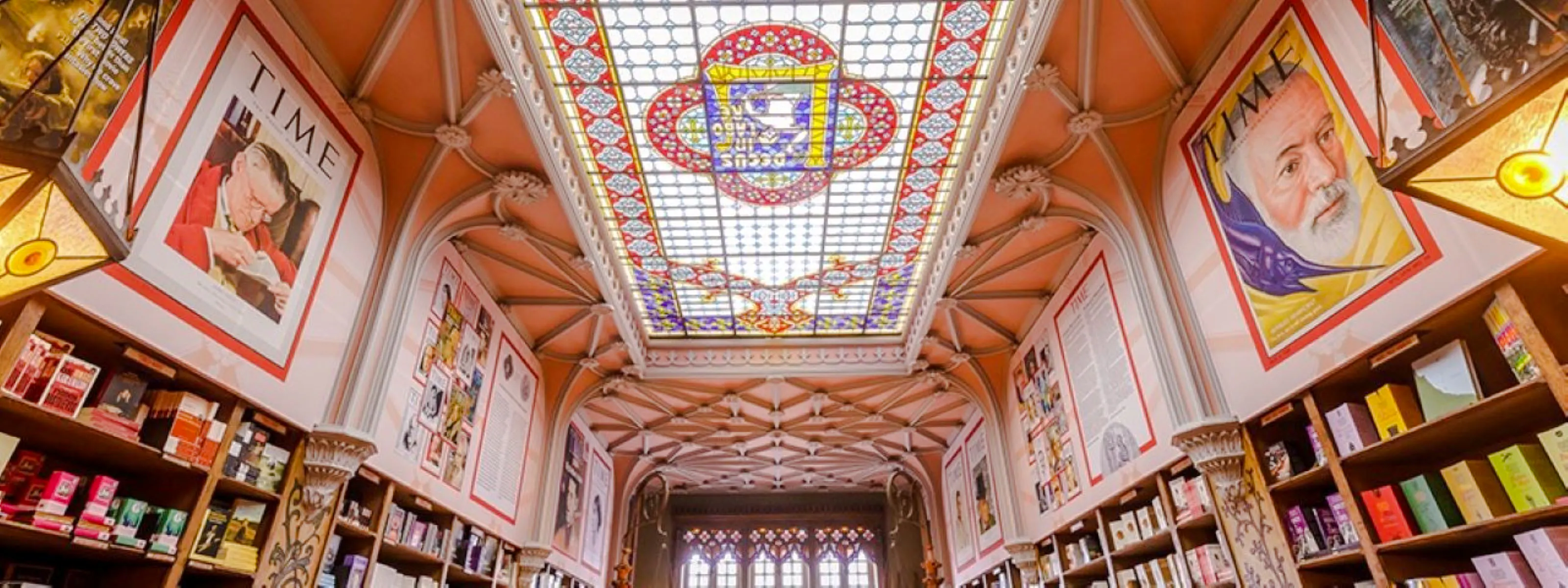 Stained glass ceiling and bookshelves inside Lello Bookstore, Porto.