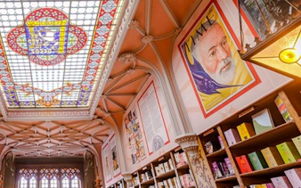 Stained glass ceiling and bookshelves inside Lello Bookstore, Porto.
