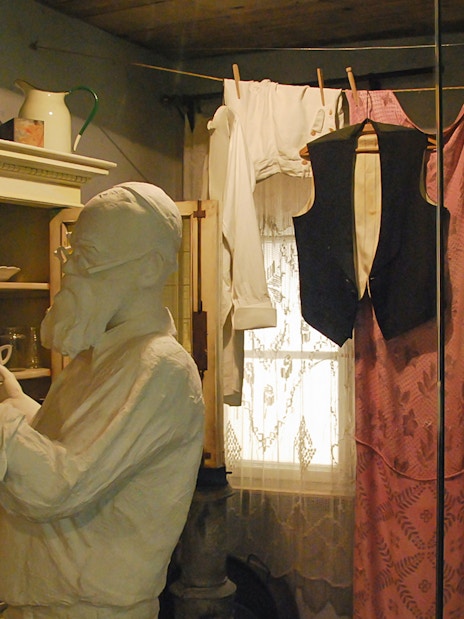Mannequin in Schindler's Factory Museum kitchen scene with vintage clothing and dishes.