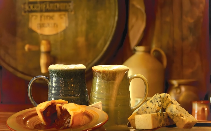 Mugs of ale with pie and cheese at Hobbiton Movie Set, New Zealand.