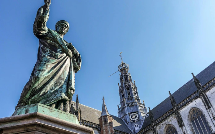 Statue of Laurens Janszoon Coster with Grote Kerk in Haarlem.