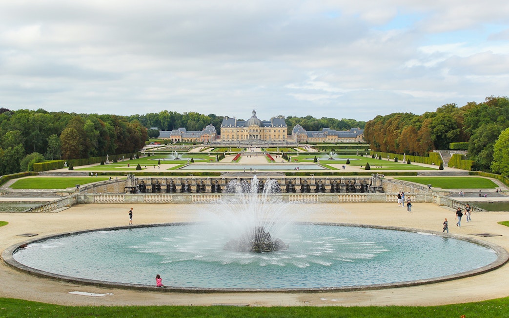 Vaux-le-Vicomte gardens with central fountain and chateau in the background, near Paris.