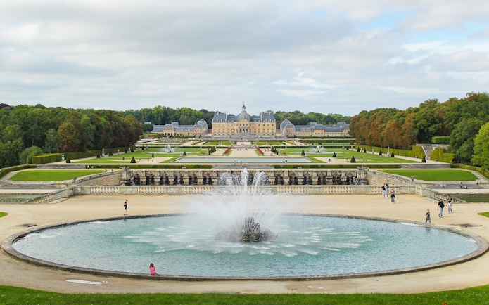 Vaux-le-Vicomte gardens with central fountain and chateau in the background, near Paris.