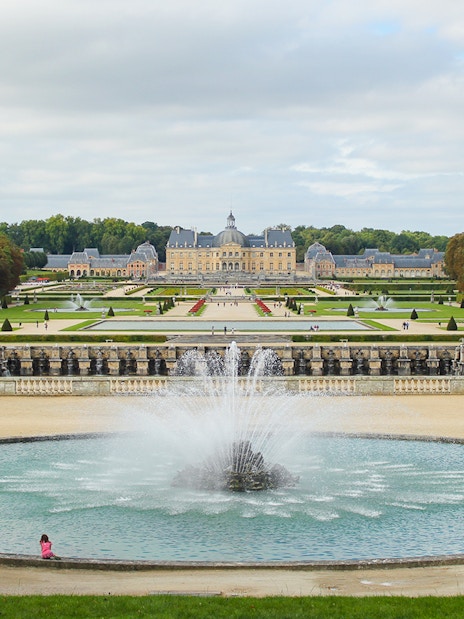 Vaux-le-Vicomte gardens with central fountain and chateau in the background, near Paris.