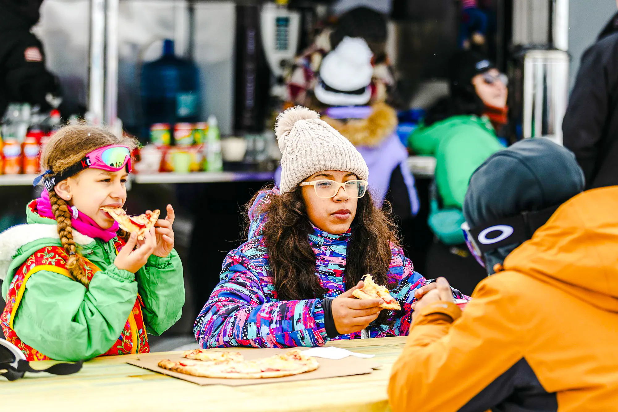 Children enjoying pizza at Farellones Park, Santiago, during a snowy day trip.