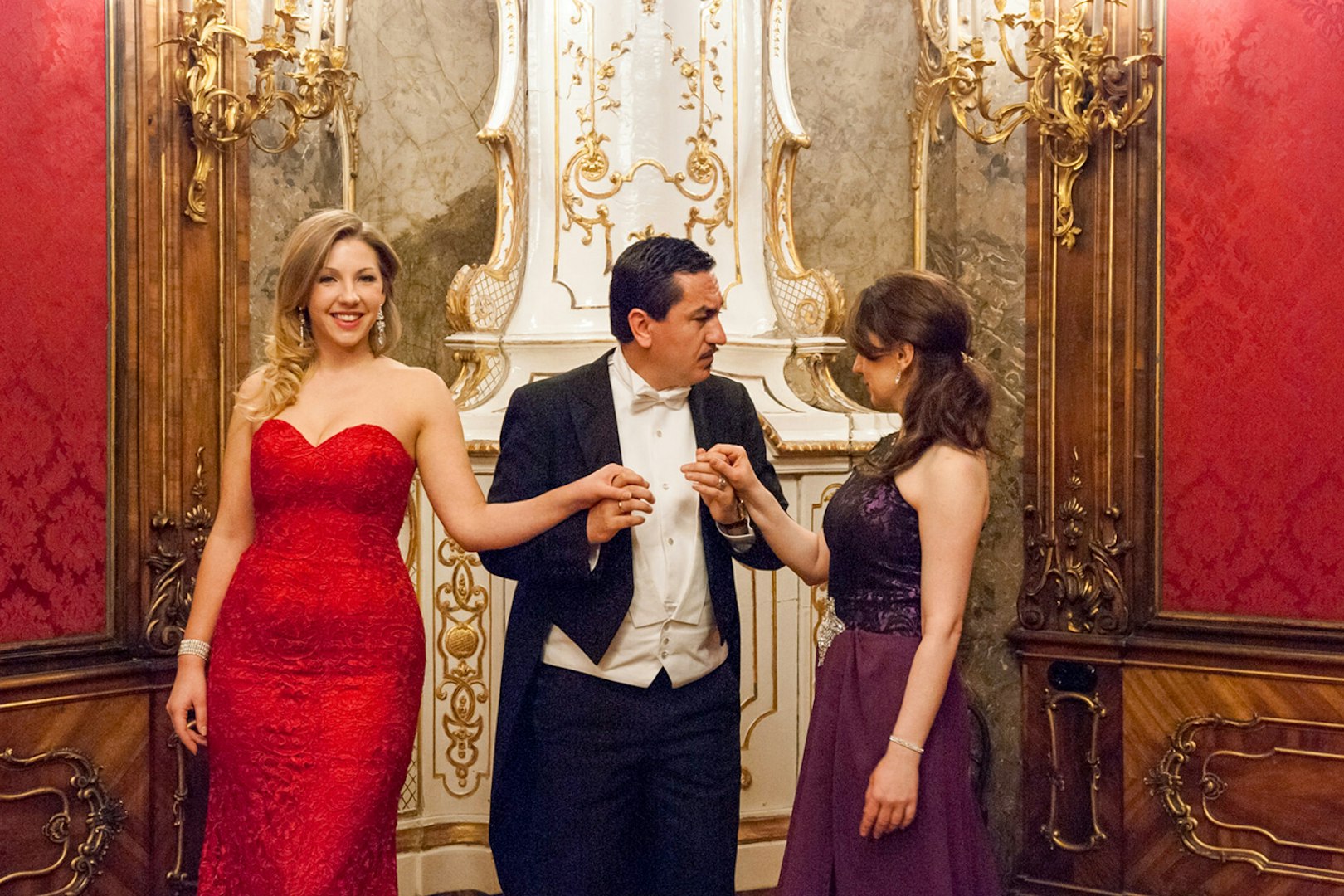 Vienna Baroque Orchestra performers in elegant attire inside a lavish concert hall.