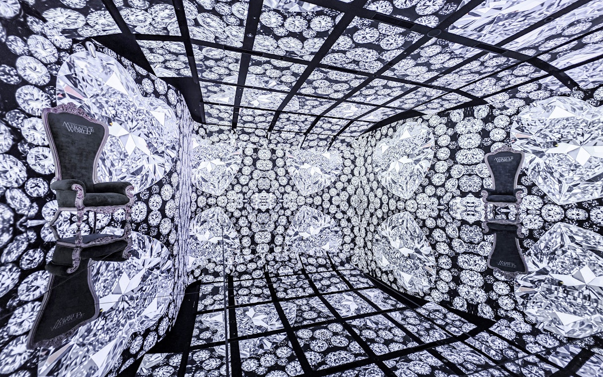 MIRACLEWORLD Osaka room with diamond-patterned walls and two ornate chairs.