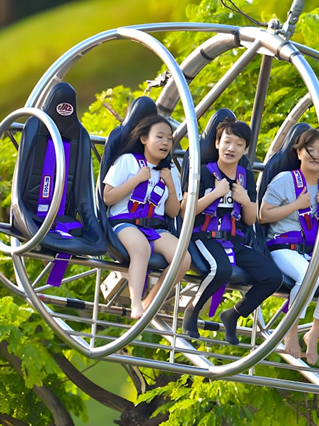 Visitors enjoying the Slingshot ride in Singapore amidst lush greenery.