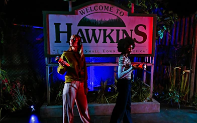 Visitors with flashlights at Hawkins sign, Stranger Things play, Netflix house, Dallas.