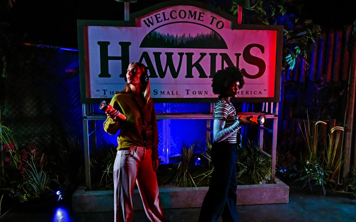 Visitors with flashlights at Hawkins sign, Stranger Things play, Netflix house, Dallas.