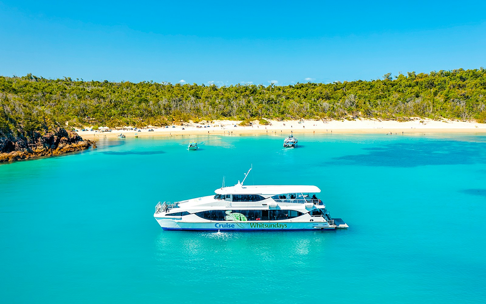 Boat near Whitehaven Beach, Whitsundays, with Great Barrier Reef backdrop.