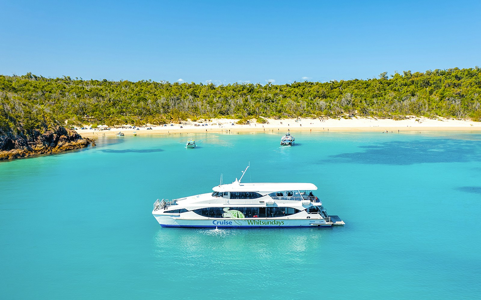 Boat near Whitehaven Beach, Whitsundays, with Great Barrier Reef backdrop.