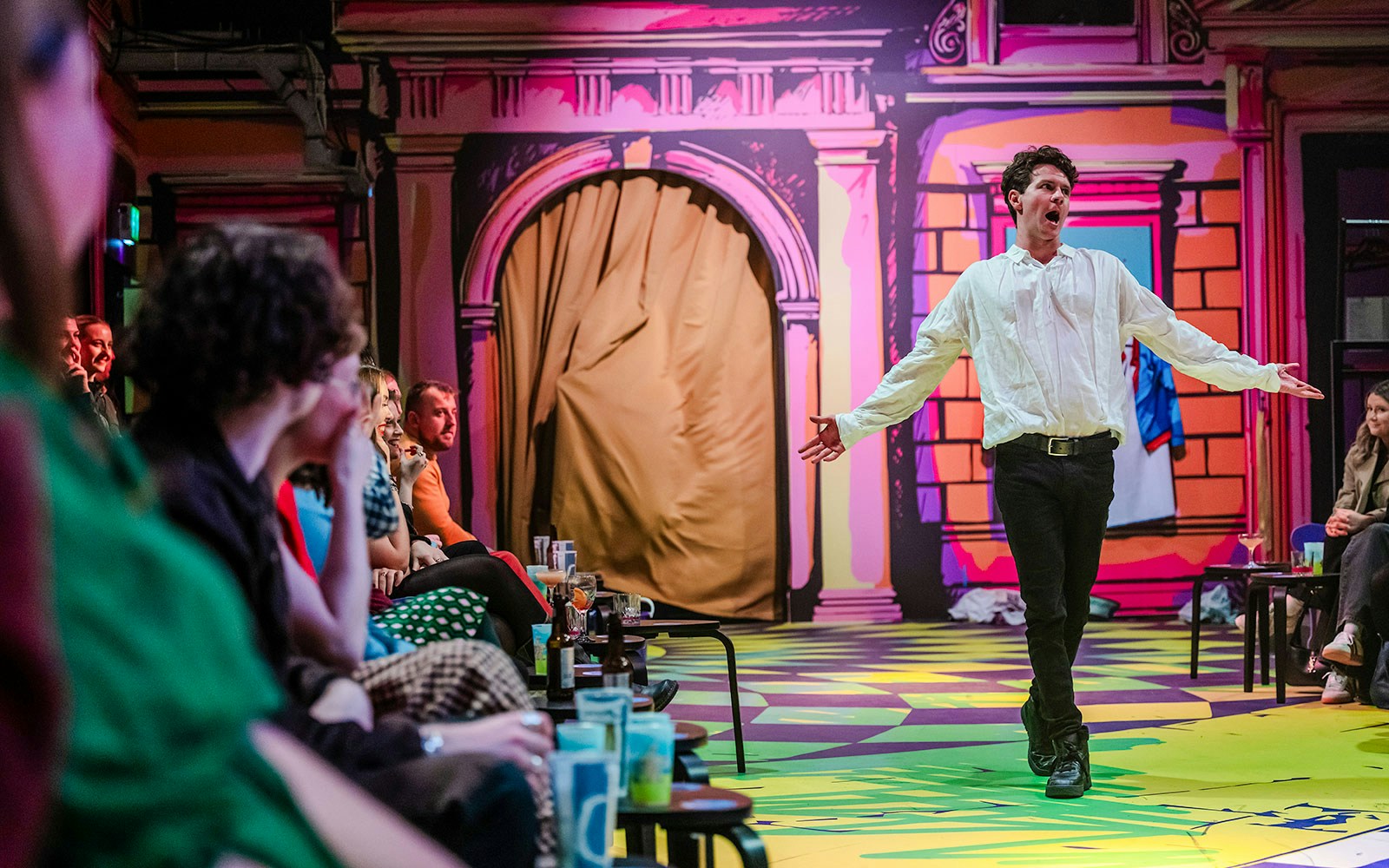 Performer engaging audience in immersive "Plied and Prejudice" theater show.