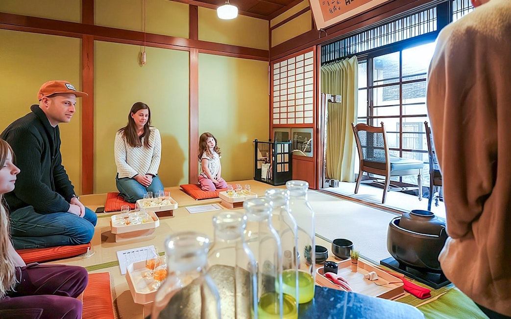 Tourists seated in a traditional Japanese house for a private tea ceremony and wagashi experience.