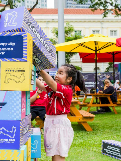 Child stacking blocks at Formula 1 Singapore Grand Prix, Marina Bay Street Circuit.