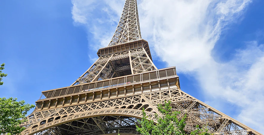 Eiffel Tower viewed from below with clear blue sky in Paris.