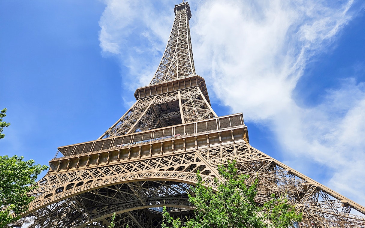 Eiffel Tower viewed from below with clear blue sky in Paris.
