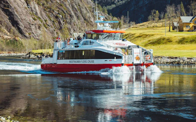 Cruise boat on Mostraumen Fjord near Bergen with passengers enjoying scenic views.