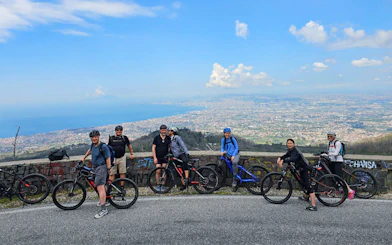 Group on e-bikes with view of Mount Vesuvius and Sorrento coastline.