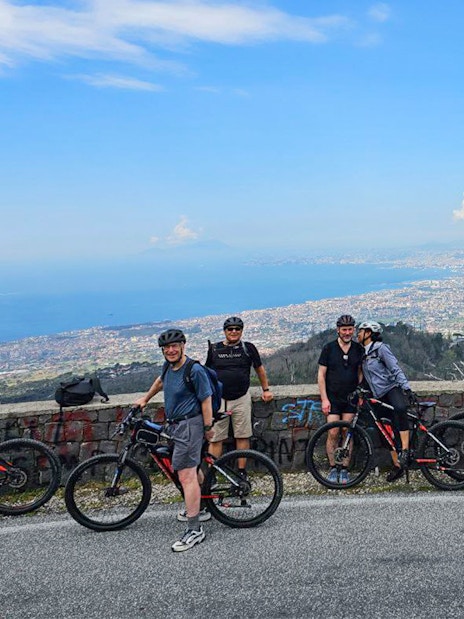 Group on e-bikes with view of Mount Vesuvius and Sorrento coastline.