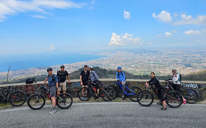 Group on e-bikes with view of Mount Vesuvius and Sorrento coastline.
