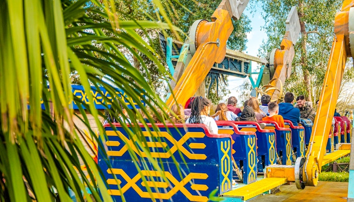 Visitors on the Quantum ride at Thorpe Park London, surrounded by trees.