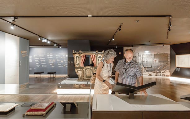 Visitors exploring a museum exhibit with historical artifacts in the Visita Clássica tour.