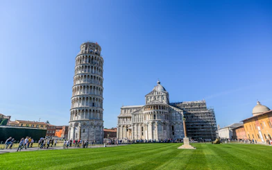 Leaning Tower of Pisa and Pisa Cathedral in Italy with tourists exploring.