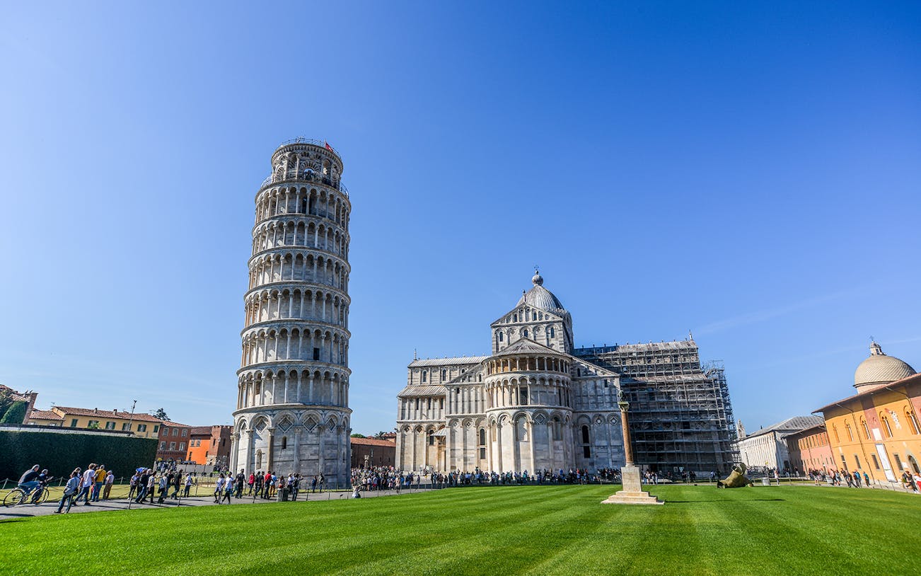 Leaning Tower of Pisa and Pisa Cathedral in Italy with tourists exploring.