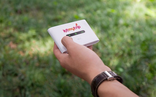 Hand holding 4G Pocket WiFi device for rental, available at DXB, AUH, SHJ airports.