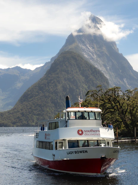 Cruise boat on Milford Sound with Mitre Peak in the background, New Zealand.