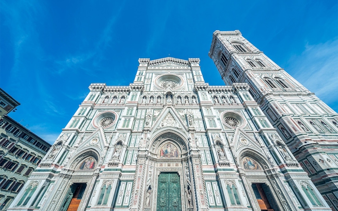 Duomo Florence facade with bell tower under blue sky.