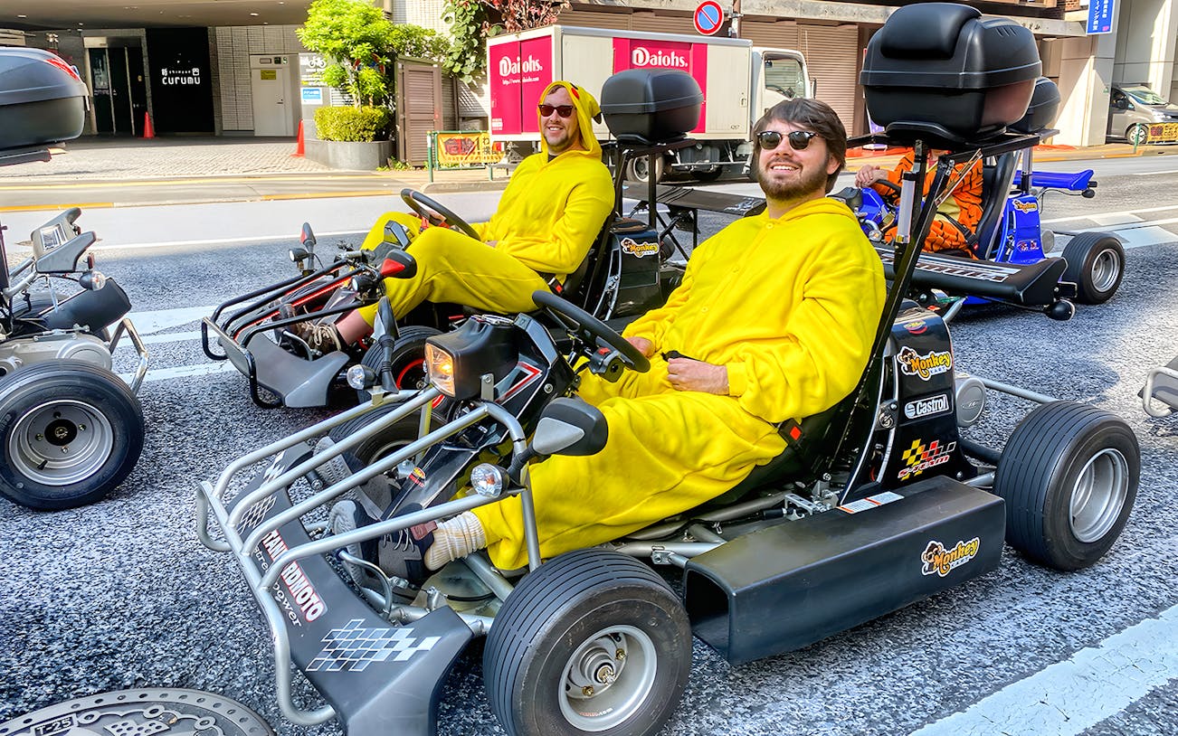 Participants in yellow costumes driving go-karts in Gotanda, Tokyo.