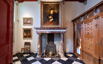 Rembrandt House Museum interior with paintings and ornate fireplace, Amsterdam.