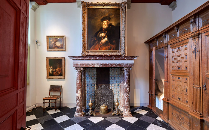 Rembrandt House Museum interior with paintings and ornate fireplace, Amsterdam.