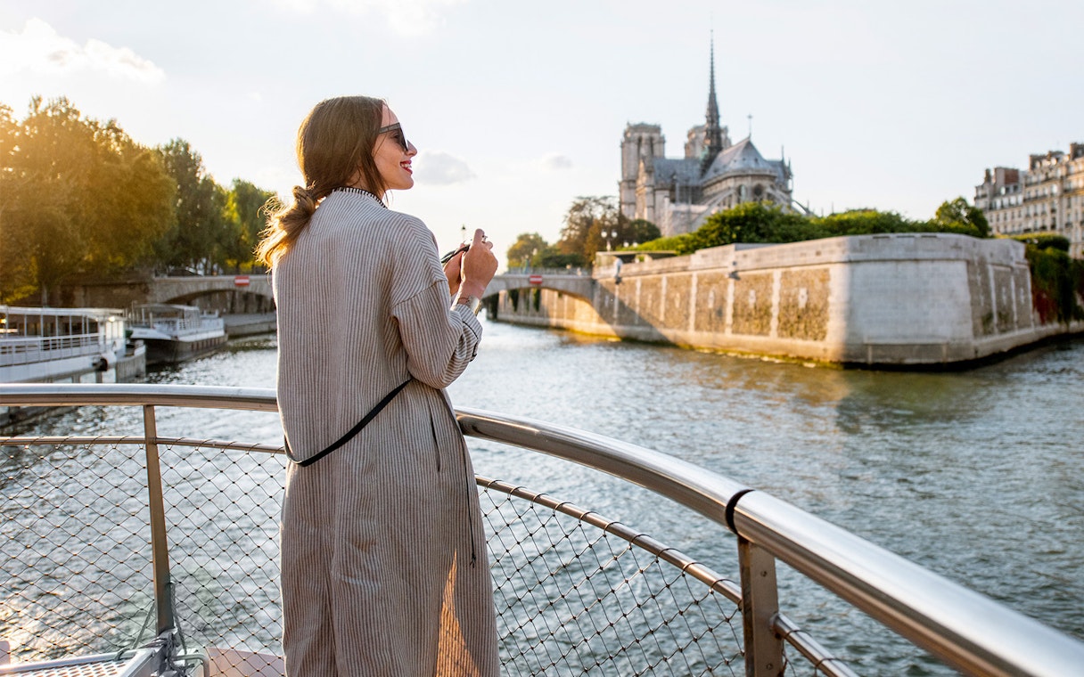 Participant enjoying Seine River Cruise with Notre-Dame Cathedral in Paris.