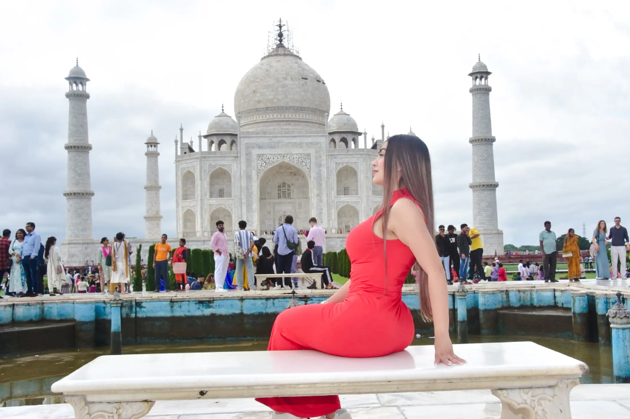 Visitors at the Taj Mahal with the iconic marble mausoleum in the background, Agra.