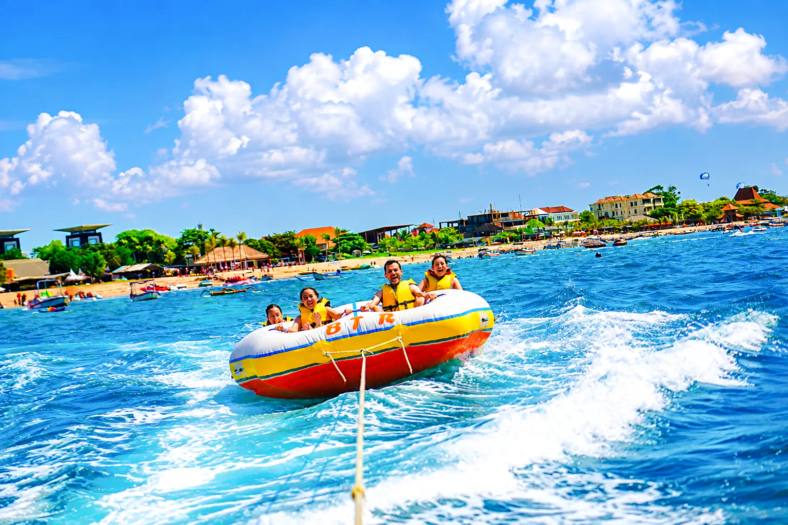 Tanjung Benoa ocean adventure with tourists on inflatable boat, Bali.