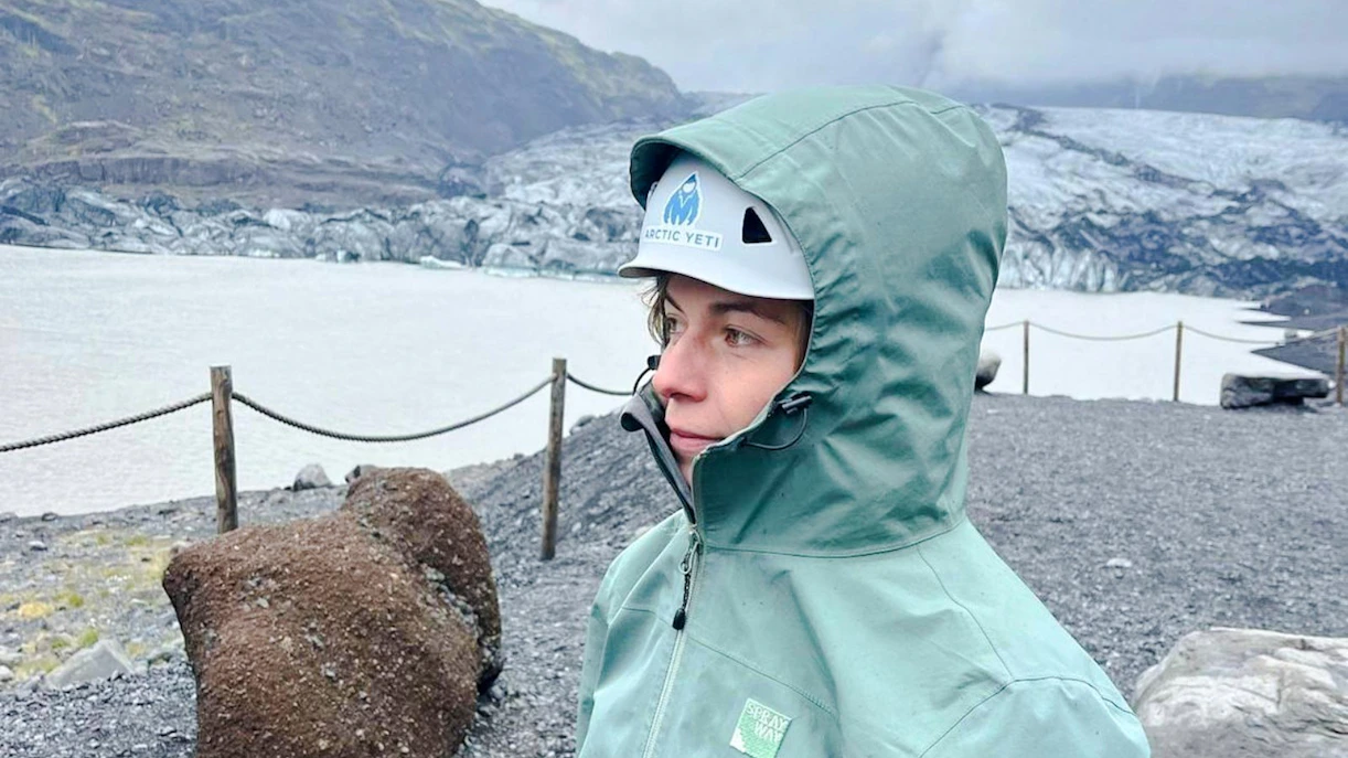 Guest in hiking gear at Sólheimajökull Glacier, Iceland, during a small group tour.