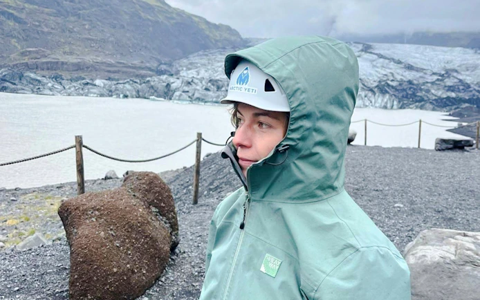 Guest in hiking gear at Sólheimajökull Glacier, Iceland, during a small group tour.
