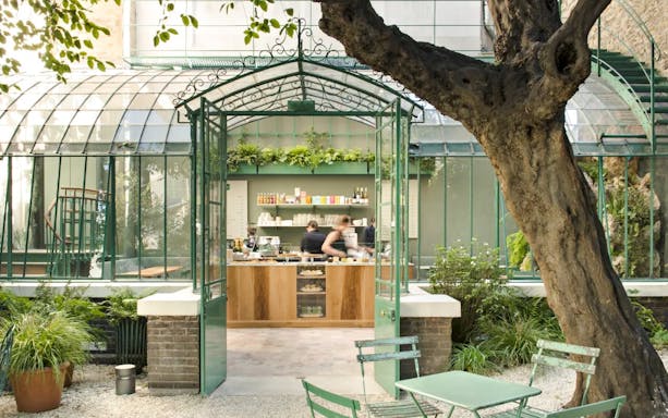 Café entrance at Musée de la Vie romantique, Paris, with green chairs and garden setting.