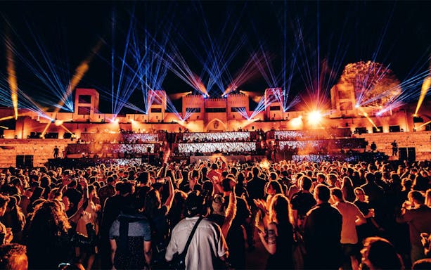 Crowd enjoying DIPLO performance with vibrant lights at Terra Solis by Tomorrowland.