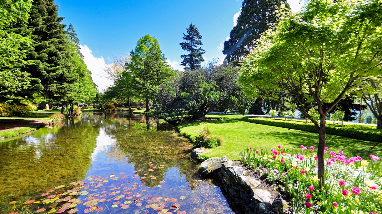 Queenstown Gardens New Zealand with lake view and lush greenery.