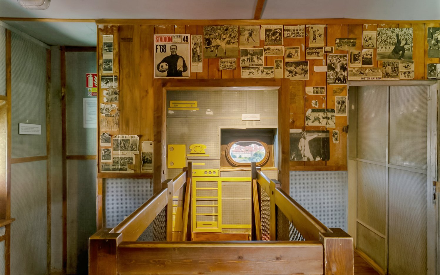 Inside view of St. Nicholas Bell Tower in Prague with historical photos on wooden walls.